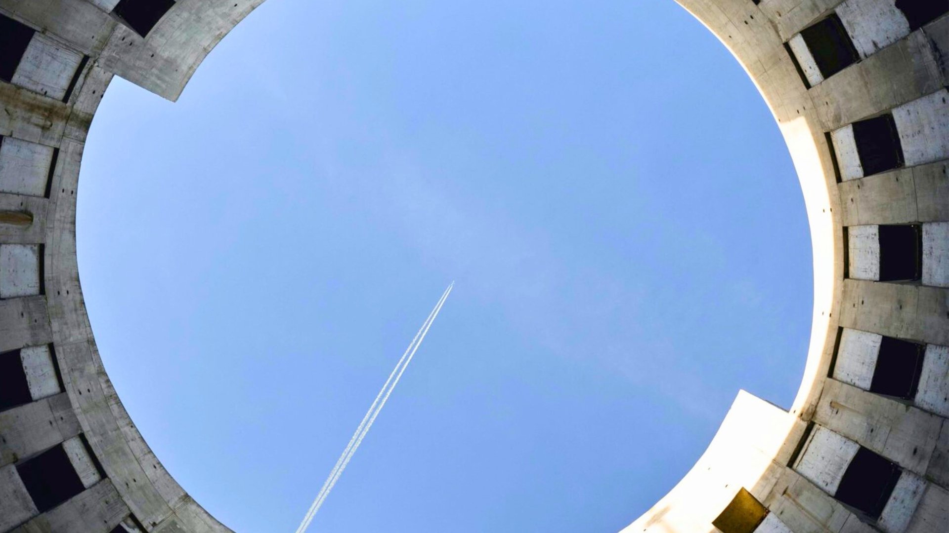 Vista dal basso di un cerchio con un aereo nel messo a simboleggiare come il PNRR abbia centrato il punto con rifiuti ed economia circolare